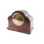 An Edwardian mahogany cased mantel clock, the circular brass dial bearing Arabic numerals,