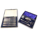 A George V silver manicure set, cased, comprising ointment jar and cover, buffer, file, pair of