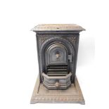 A Victorian cast iron wood burner, of rectangular section, the front arch door opening to reveal