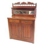 A Victorian mahogany chiffonier, with a carved and broken arch pediment, over a single shelf, raised