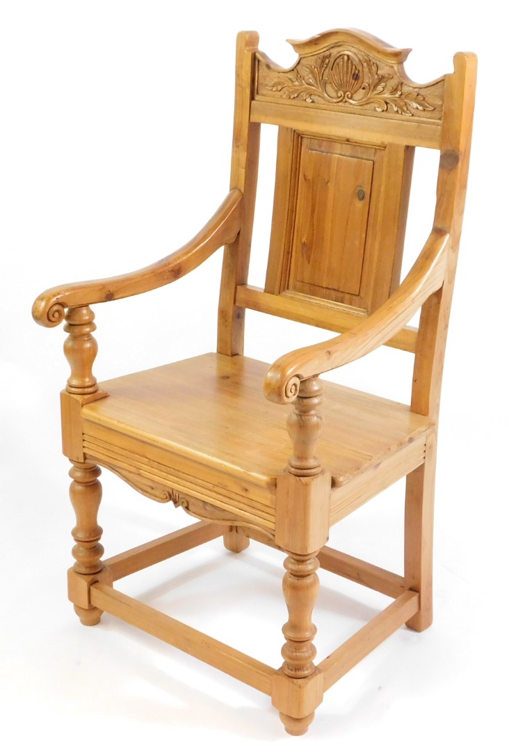 A pine carver chair, with fan and foliate carved crest rail, rectangular panelled back, solid