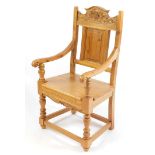 A pine carver chair, with fan and foliate carved crest rail, rectangular panelled back, solid