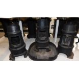 Three cast iron multi fuel burners, of chimney form, one with a base stand, 48cm high. (4)