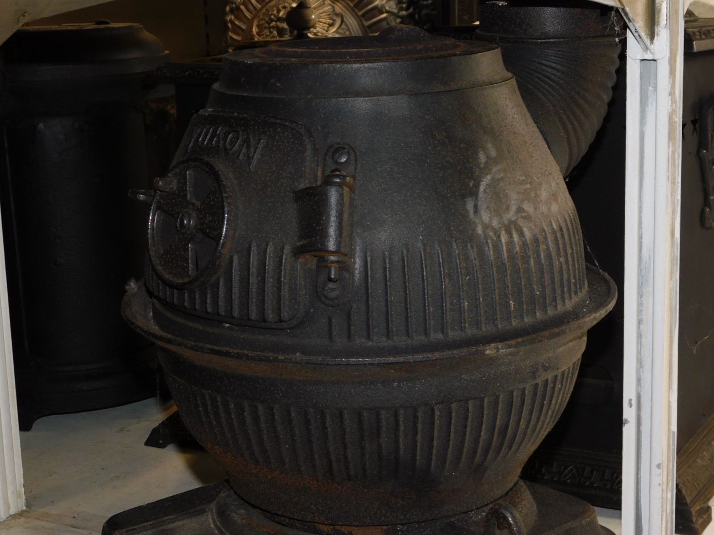 A Masport Yukon late 19thC cast iron pot belly stove, of fluted globe form, raised on an iron base - Image 2 of 4