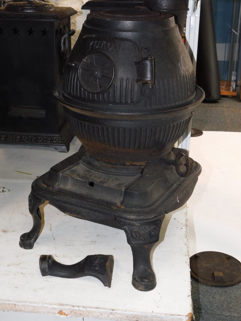 A Masport Yukon late 19thC cast iron pot belly stove, of fluted globe form, raised on an iron base
