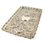 An Edward VII silver dressing table tray, of rectangular form, embossed with masks, birds and