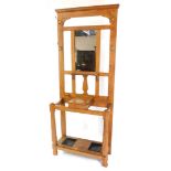 A Victorian oak hall stand, with a mirrored back and coat hooks, central hinged glove box, over a
