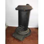 A cast iron cylindrical wood burning stove 'The Summerford', raised on a shaped hearth base, 82cm