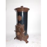 A Godin 20thC cast iron enamel and tin wood burning stove, of cylindrical form, raised on three