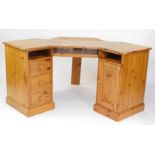 A pine corner desk, with three drawers, single cupboard door and pull out keyboard shelf, 82cm high,