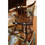 A dark beech rocking chair, with spindle back and turned legs and stretchers.