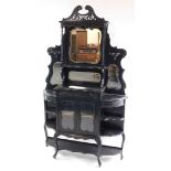 An early 20thC ebonised mirror back cabinet, with shelves and recesses, raised on cabriole legs,