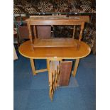 An oak veneered drop leaf dining table, enclosing four folding chairs, 75cm high, 136cm wide, 87cm