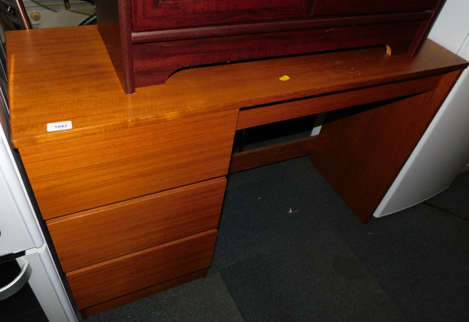 A teak effect dressing table, with three left hand drawers, 73cm high, 111cm wide, 40cm deep.