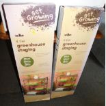 A pair of Wilko four tier greenhouse staging, boxed.