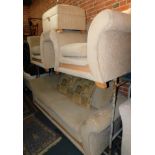 A four piece suite upholstered in a beige fabric.