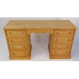 A waxed pine desk or dressing table, with eight drawers, 77cm high, 137cm wide, 46cm deep.