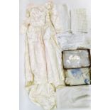 A quantity of linen and lace, to include lace tablecloths and place mats, a wedding gown and a