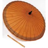 An Eastern parasol, with top orange coloured material with three way black stripe, on bamboo stem,