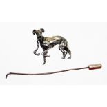 A late 20thC greyhound stick pin, the top with a silver coloured greyhound with red cabochon eyes,