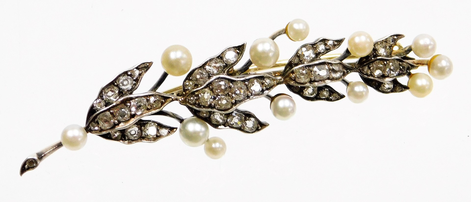 A Victorian diamond and pearl leaf brooch, the brooch formed of a leaf branch with three strand