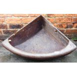 A cast iron corner feeding trough, 70cm high, 90cm deep.