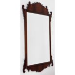An early 19thC mahogany fret framed wall mirror, the top and bottom with pierced carved design, on a