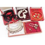 A group of costume jewellery necklaces, to include a three strand shell necklace, a gold plated