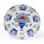 An 18thC Dutch Delft plate, with painted decoration of flowers in blue, red and green, 22cm