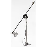 An industrial adjustable floor lamp, on a angle top with shaped shade, on a tripod base, 183cm