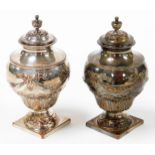 A pair of old Sheffield plate tea caddies, each shaped as an urn, with bow and scroll decoration, on