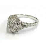 An ornate diamond cluster ring, set with central round brilliant cut diamond, surrounded by eight