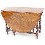 A late 19thC oak drop leaf table, on turned supports, 73cm high, 102cm wide, 44cm deep, 146cm