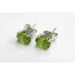 A pair of peridot studs, in silver with butterfly backs, 2.9g all in.