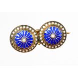 A silver gilt and enamel brooch, comprising two circles, each with blue enamel decoration, with
