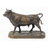 A 20thC bronze figure of a standing bull, on a rustic base, 24.5cm high.