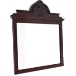 A walnut framed wall mirror, the moulded cornice top of oval form with scrolls and vines, with