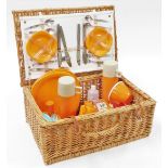 A 1960's sunflower wicker picnic basket set, the wicker hamper with orange plastic plates and bowls,