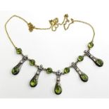 An Art Nouveau style polished peridot and diamond necklace, set with five oval polished peridots and