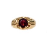 A 9ct gold dress ring, the central oval garnet in claw floral cluster type pierced setting, ring