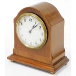 An Edwardian mahogany mantel clock, with a marquetry banded scroll border, on brass bun feet