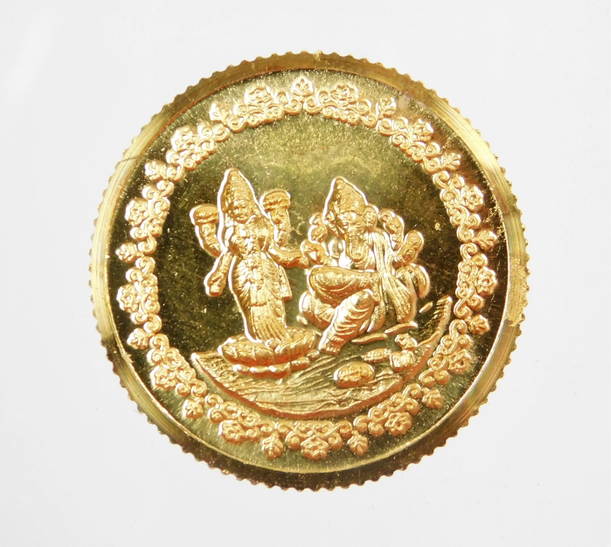 A Tanishq gold coin, depicting two Hindu figures, stamped 995 fine gold, 10g, in presentation sleeve