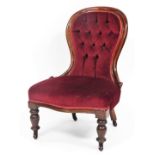 A Victorian button back nursing chair, the mahogany frame with red button velvet seat, on turned