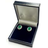 A pair of 9ct gold emerald and diamond cluster earrings, with oval emerald surrounded by round