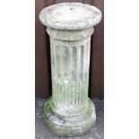 A reconstituted stone garden plinth, the circular top over a reeded column, on a stepped base,