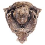 A terracotta wall shelf, with figure of a child and set with ferns and wheatsheaf, 27cm high, 29cm