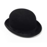 A Lock and Co bowler hat, with plain ribbon border pulled with a cream material interior stamped