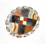 An agate oval broach, in a silver plated weaved frame, the central agate panel with various cut