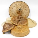 A collection of various Eastern wicker hats, of varying design and styles, the largest, 54cm