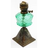 A Victorian aesthetic oil lamp base, the green glass reservoir on a square tapered metal base with